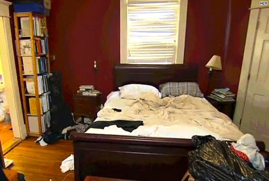 This cluttered bedroom with dark, gloomy red walls will not attract buyers!