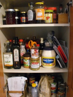 Cluttered pantry cupboard.