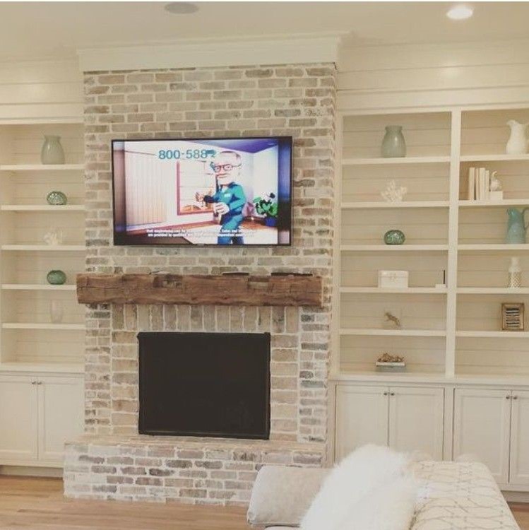 Neutral colored living room with white-washed fire place.