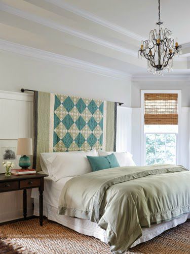 Bedroom with a beautiful quilt as a headboard.