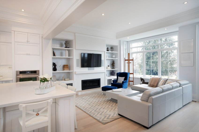 Open concept living room and kitchen in white with blue accents.