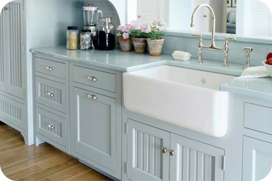 Kitchen with painted blue cabinets and a white farmhouse sink. Decorate in the farmhouse style.