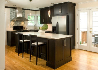 Staged kitchen with island and round leafed plants.