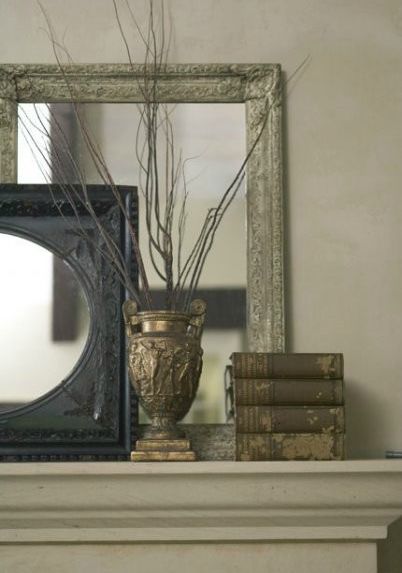 Fireplace mantle with leaning mirrors.