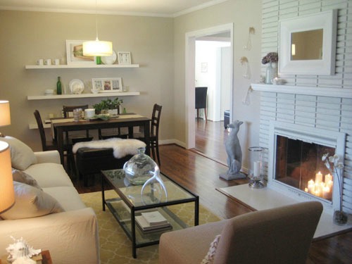 Living room with floating shelves and a glass coffee table top.