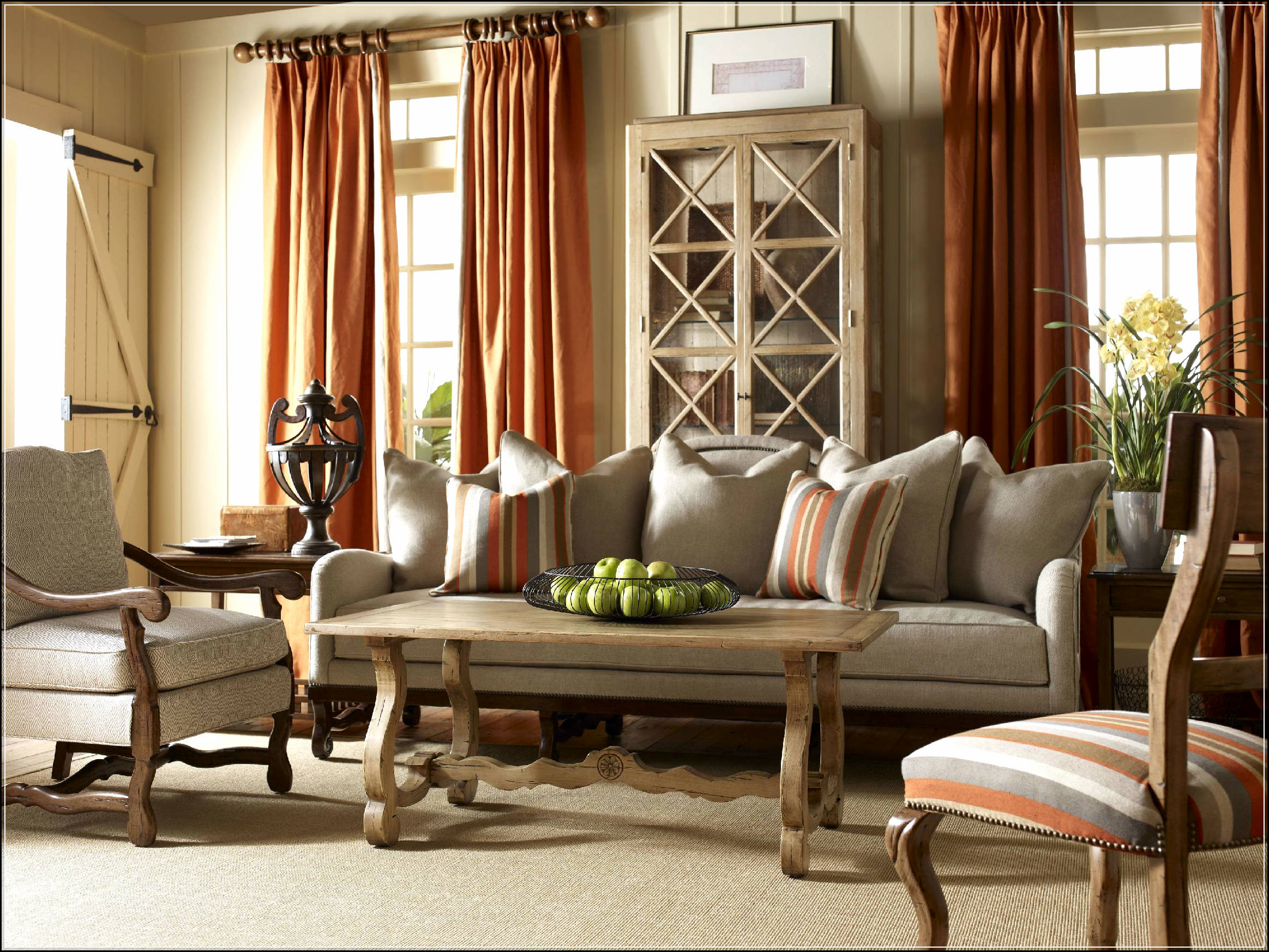 Large living room with neutral background and orange accessories.