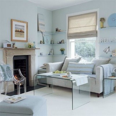 This small living room is decorated with a lucite coffee table, side tables and chair, which appear to take up no space.