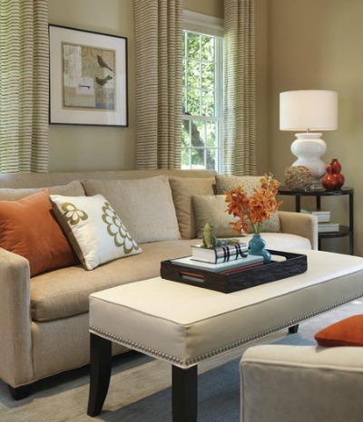 Neutral colored living room with evenly distributed orange addents.