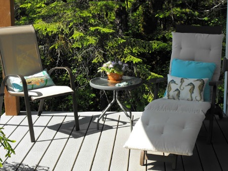 Create a cozy deck vignette with outdoor furniture.