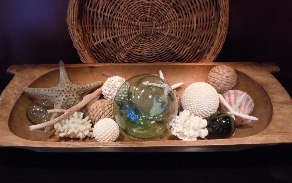 Wood bowl vignette filled with sea shells and glass balls.